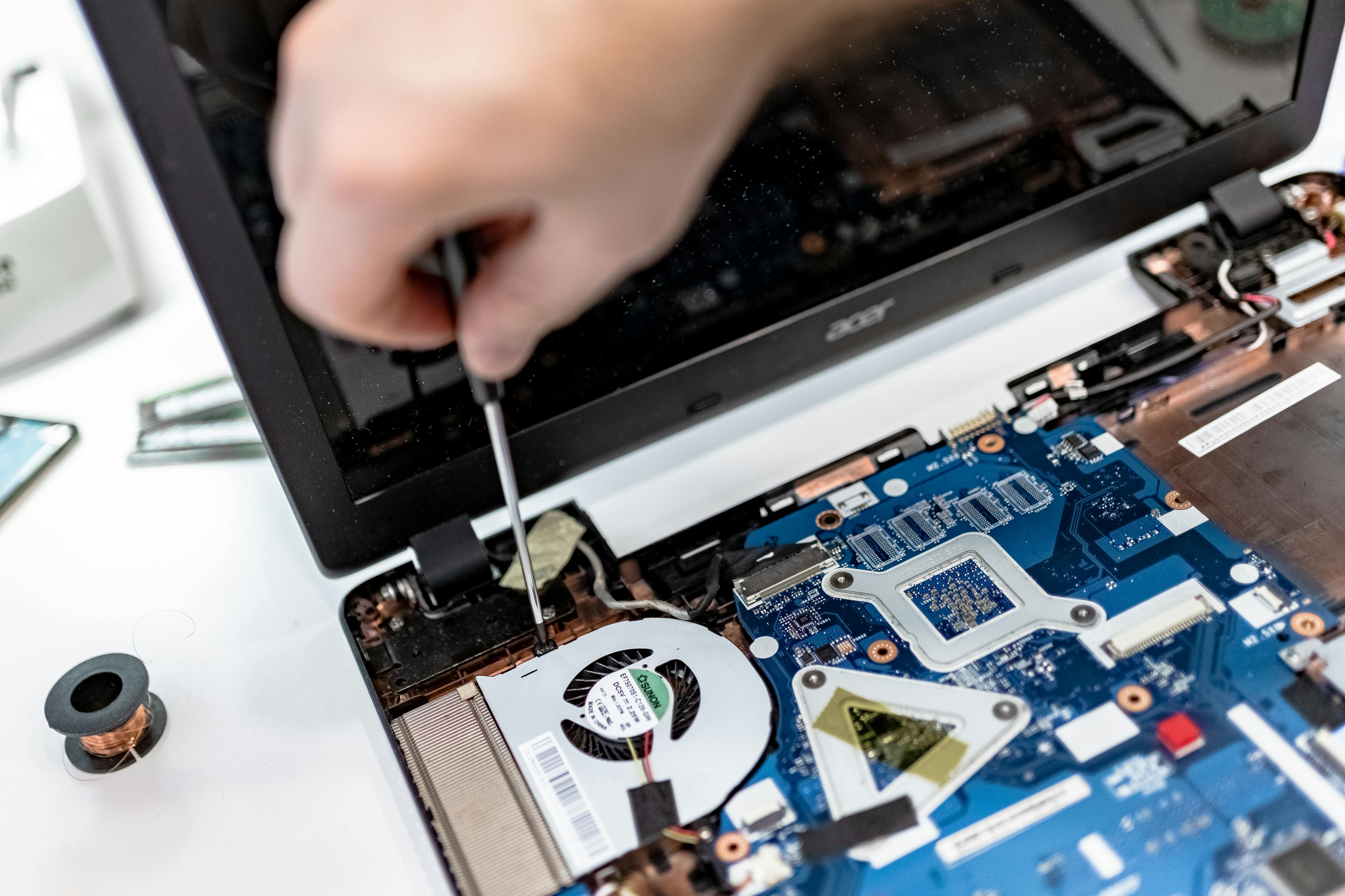 Technician working on a laptop motherboard